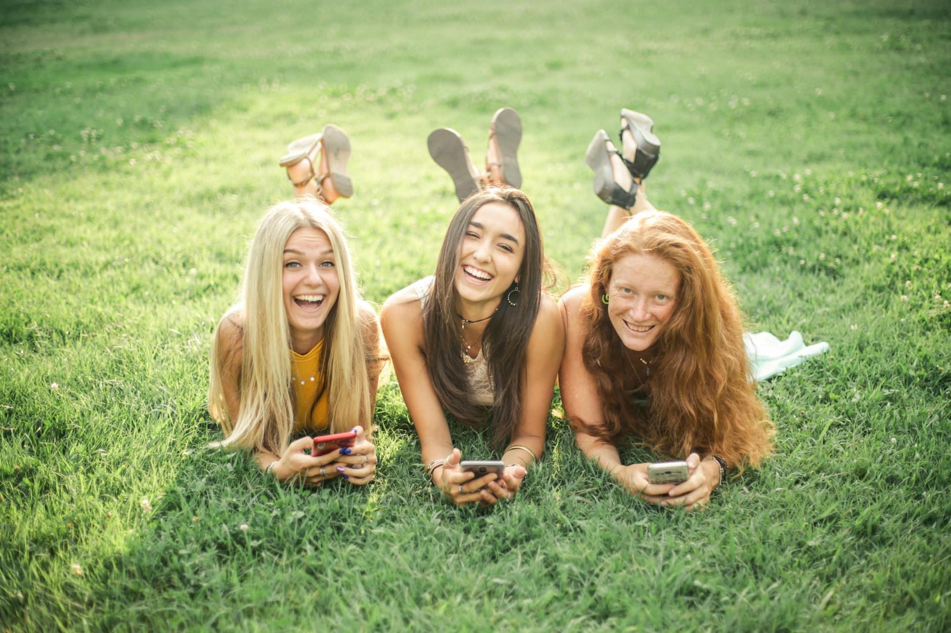 happy female friends resting in park